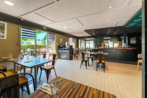 a dining room with tables and chairs in a restaurant at Campanile Lille Est - Villeneuve D'ascq in Villeneuve d'Ascq