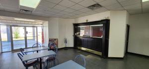 a classroom with tables and chairs and a large door at Super 7 Inn in Midland