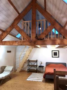 a attic room with a bed and a wooden ceiling at La Grange de La Hague YourHostHelper in Auderville