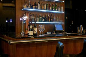 a bar with a bunch of bottles of alcohol at The Queens Gate Hotel in London