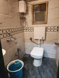 a bathroom with a toilet and a sink at Sinhassan dormitory hostel Juhu in Mumbai