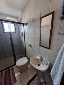 a bathroom with a toilet and a sink and a shower at Quarto na região central com alexa integrada e sacada in Curitiba