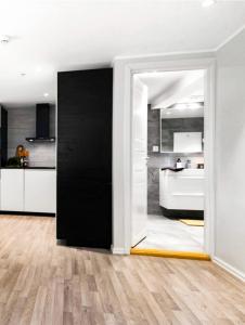 une chambre avec une porte noire et une cuisine dans l'établissement Solsiden Modern stay: King Beds, Private Entry, à Trondheim
