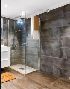 La salle de bains est pourvue d'une douche avec une porte en verre. dans l'établissement Solsiden Modern stay: King Beds, Private Entry, à Trondheim