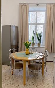 a dining room table with chairs and a window at Apartament Familijny in Przemyśl