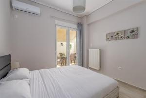 - une chambre blanche avec un lit et une fenêtre dans l'établissement Marina Zeas Hidden Gem, au Pirée
