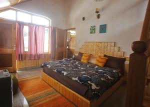 une chambre avec un grand lit dans une pièce dans l'établissement Gharsa Homestay, à Manali