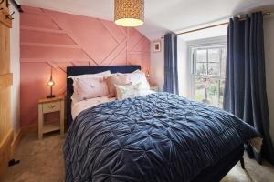 a bedroom with a large bed and a pink wall at Host & Stay - Lime Tree House in Holme