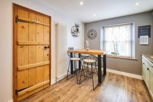 a kitchen with a table and stools next to a door at Host & Stay - Lime Tree House in Holme