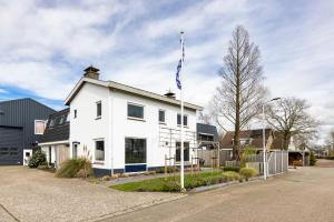 a white building with a flag on top of it at Weeruusz in Kolderwolde