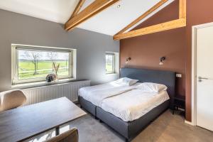 1 dormitorio con cama, mesa y ventana en Weeruusz, en Kolderwolde