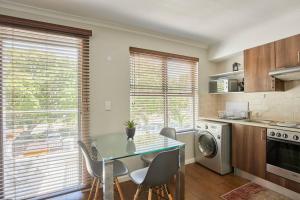 Una cocina con una mesa y sillas en una habitación. en The Rondebosch Easy Living, en Ciudad del Cabo 16 fotos más