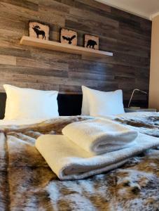 1 dormitorio con 1 cama con pared de madera en Kvitfjell Hotel, en Strande