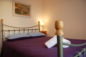 1 dormitorio con 1 cama con colcha púrpura y una foto en Seagull Beach House, en Tywyn