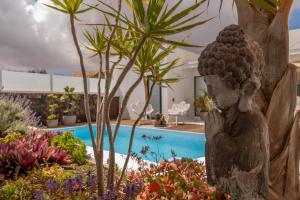 a statue in a garden next to a pool at Villa Shepherd Lajares - LUXURY VILLA FUERTEVENTURA in Lajares