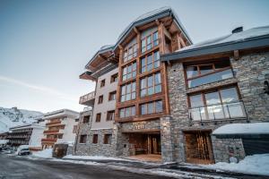 um edifício numa rua com neve em Chalet Hotel Yeti em Tignes