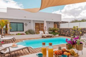 een villa met een zwembad en een patio bij Villa Shepherd Lajares - LUXURY VILLA FUERTEVENTURA in Lajares