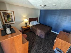 a small hotel room with a bed and a desk at Bea's Parkway Inn in Mount Airy