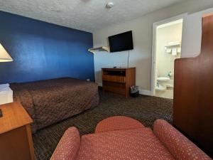 a hotel room with a bed and a tv at Bea's Parkway Inn in Mount Airy