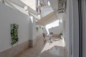 un couloir avec des murs blancs, une table et des chaises dans l'établissement Marina Zeas Hidden Gem, au Pirée