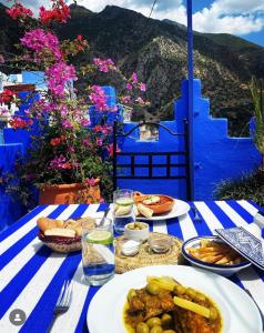 una mesa con comida en un mantel azul y blanco en Dar Zambra, en Chefchaouen