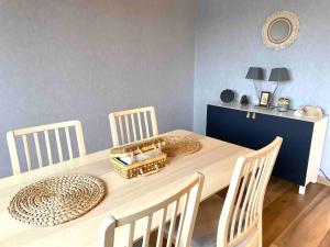 uma mesa de jantar com cadeiras e uma parede azul em Le bellevue (parking gratuit) em Besançon
