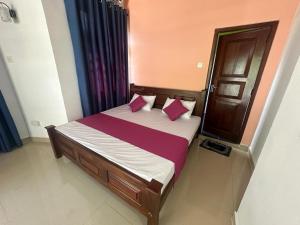 a bed with pink and purple pillows in a room at Rafting Reach Layathraa in Nawalapitiya