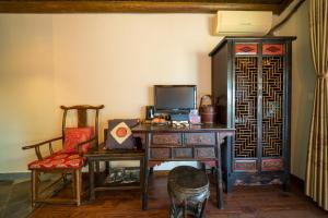 a room with a desk with a computer and a chair at Yangshuo Tea Cozy in Yangshuo