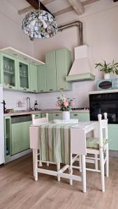 una cocina con armarios verdes, mesa y sillas en Messer Niccolò - Apartment in Florence, en Florencia
