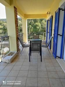 porche con mesa y sillas en el balcón en KAZARMA Luxury House, en Pilikáta