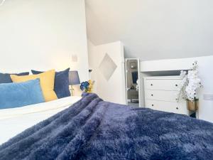 ein Schlafzimmer mit einer blauen Decke auf einem Bett in der Unterkunft Sandringham House Serviced Rooms in Hartlepool