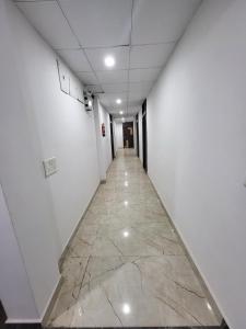 an empty hallway with a marble floor and white walls at AMALTAAS HOMESTAY in Gwalior