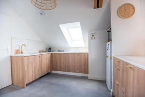 een keuken met houten kasten en een klok aan de muur bij L'appartement Bohême in Angers