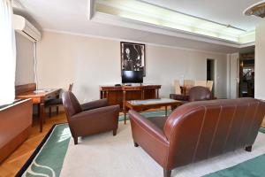 sala de estar con sillas de cuero y TV en Sole Mio Wellness & SPA en Novi Sad