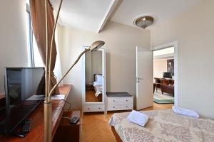 a bedroom with a bed and a desk with a lamp at Sole Mio Wellness & SPA in Novi Sad