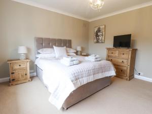 a bedroom with a large bed and a television at The Crib in Llandudno