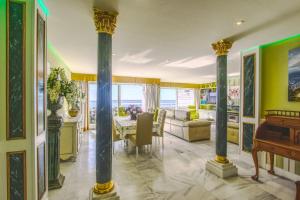 een woonkamer met zuilen en een eetkamer bij 1149 Unique beachfront Penthouse Marbella Center 400m2 in Marbella