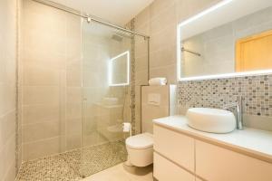 uma casa de banho com um WC e uma cabina de duche em vidro. em Luxury Villa Marbella em Marbella