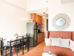 a living room with a couch and a table and a refrigerator at The Loop Studio at 5th floor Limketkai Mall infront Atrium Lucky 11 in Cagayan de Oro