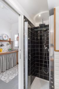a bathroom with a shower with black tiles at La Casa nel Cortile in Vico Equense