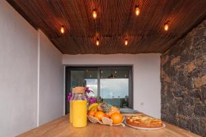 a table with a plate of fruit and a bottle of juice at Villa Shepherd Lajares - LUXURY VILLA FUERTEVENTURA in Lajares