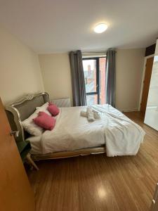 een slaapkamer met een bed met roze kussens erop bij Tony's Court Beautifully furnished 2 Bedrooms apartment in Colindale