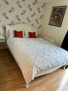 een slaapkamer met een wit bed met rode kussens bij Tony's Court Beautifully furnished 2 Bedrooms apartment in Colindale