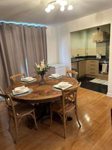 uma mesa de jantar com cadeiras e uma cozinha em Tony's Court Beautifully furnished 2 Bedrooms apartment em Colindale