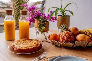 a table with fruit and juice and a plate of bread at Villa Shepherd Lajares - LUXURY VILLA FUERTEVENTURA in Lajares