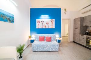 a living room with a chair and a blue wall at Napoli Centro Casa Vacanza in Naples +85 photos