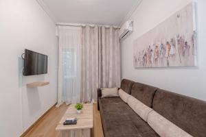 sala de estar con sofá y TV en Kallithea Gardenspot en Atenas