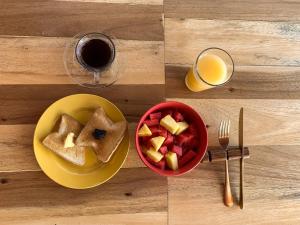 una mesa con un plato de gofres y un bol de fruta en The Wabi Sabi en León