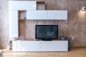 a living room with a tv on a white entertainment center at Apartment Antique Theatre 4 in Stara Zagora