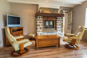 een woonkamer met twee stoelen en een open haard bij La maison de la petite lande in Saint-Jean-du-Doigt